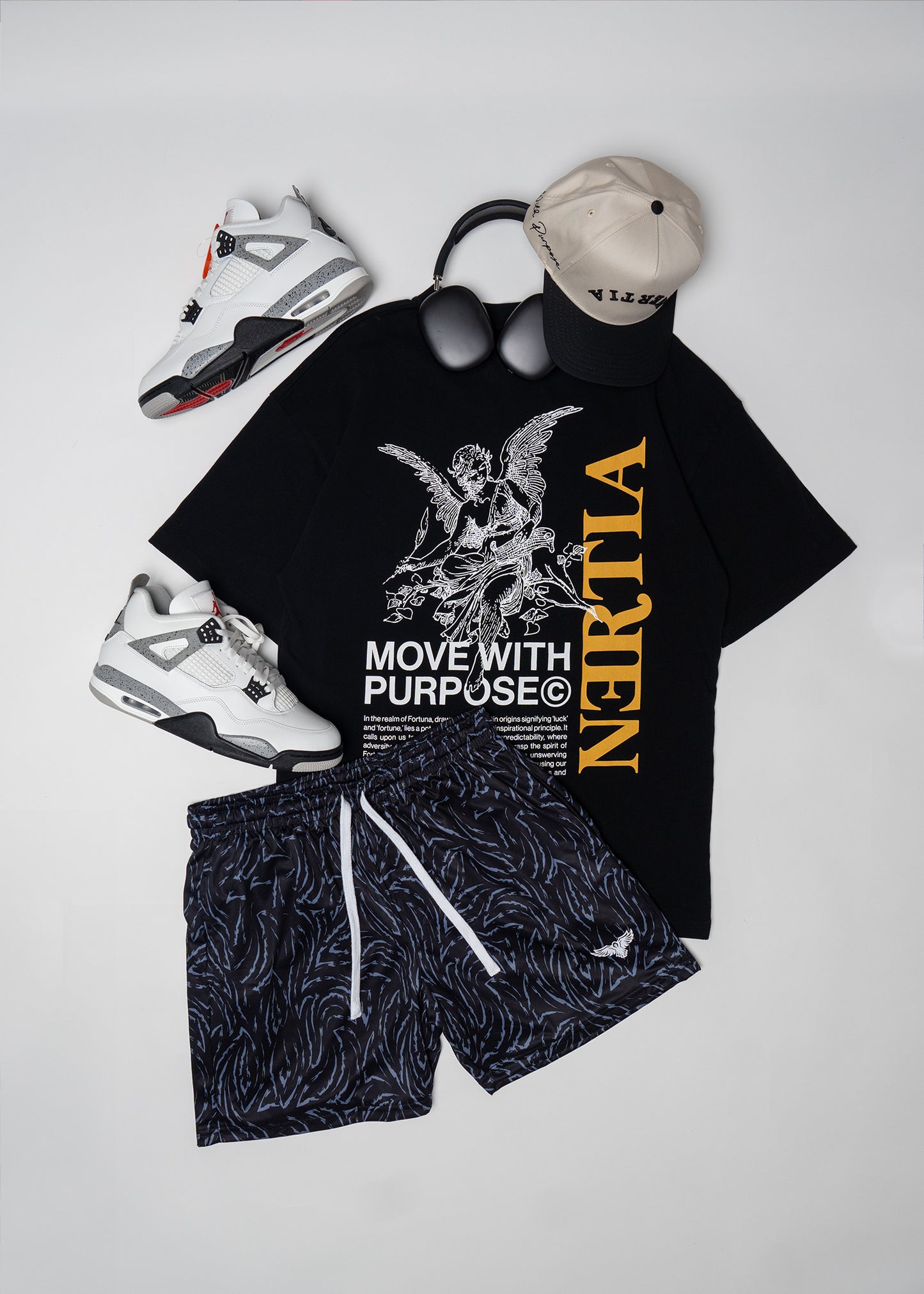 Black t-shirt with graphic design and text, black shorts, sneakers, and cap on a light gray background