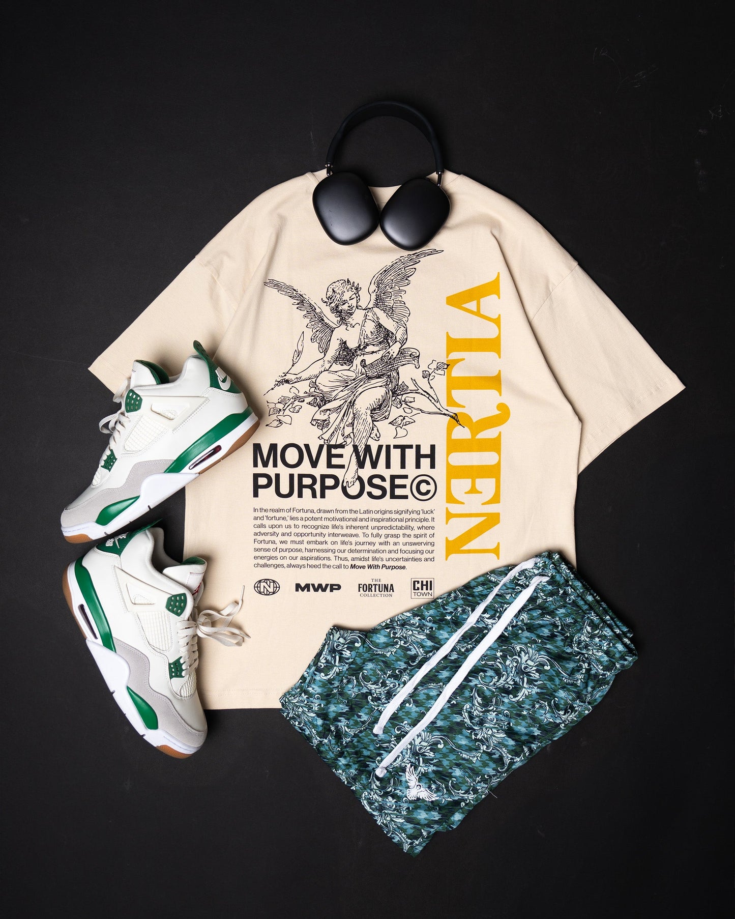 Beige t-shirt with graphic design, white sneakers, green shorts, and sunglasses on a black background