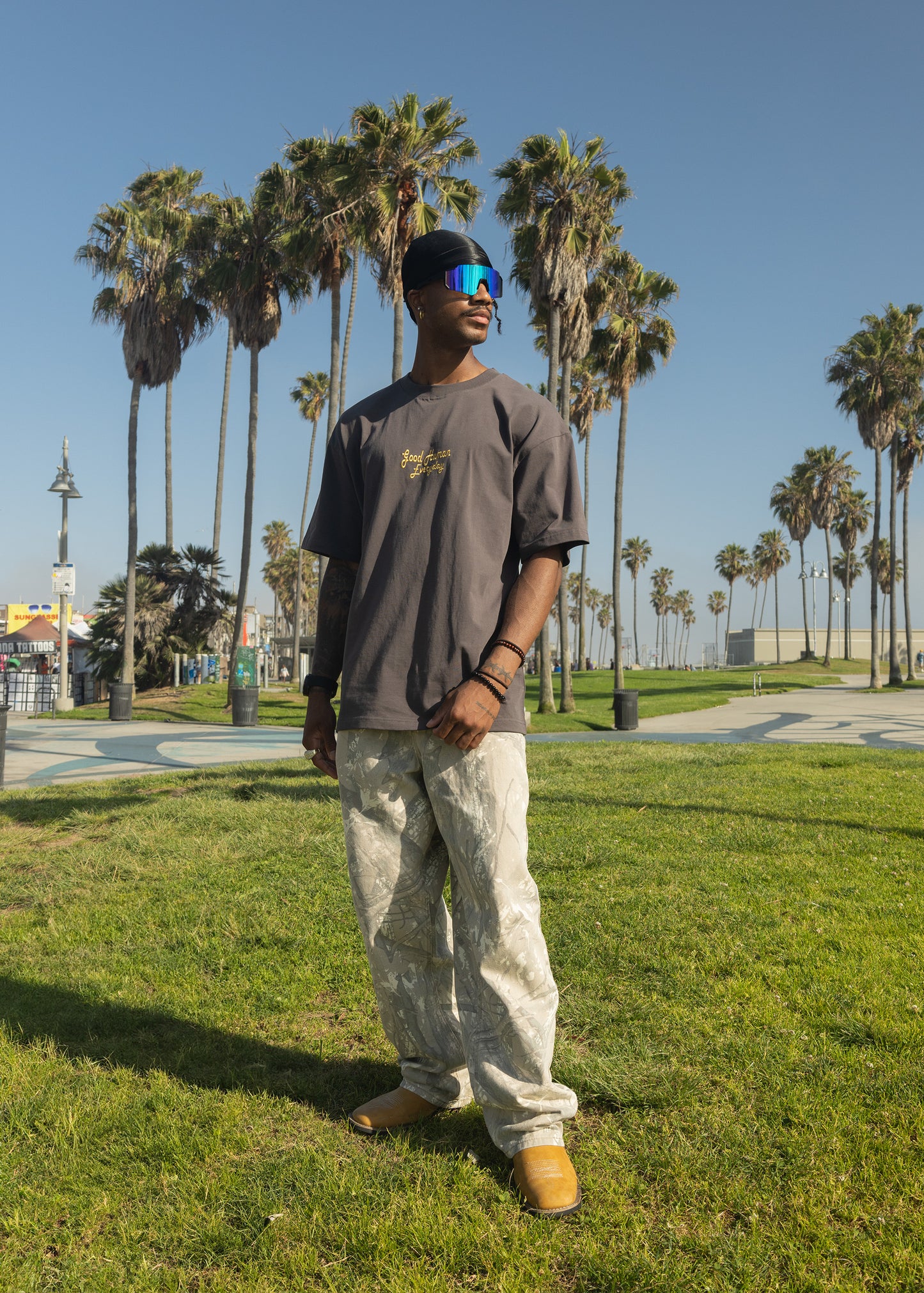 Man standing in a park with palm trees in the background