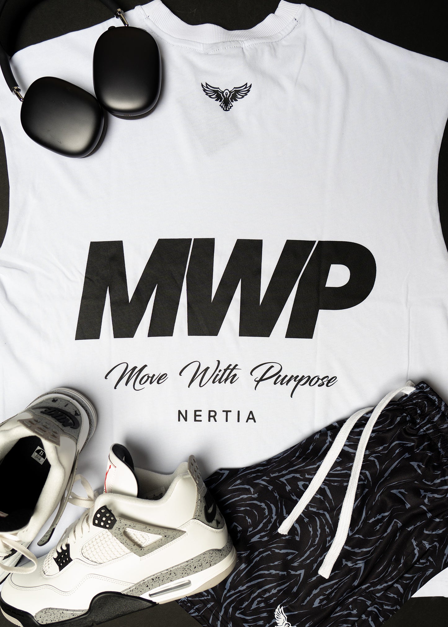 White t-shirt with 'MWP Move With Purpose NERTIA' text, sunglasses, and sneakers on a black background