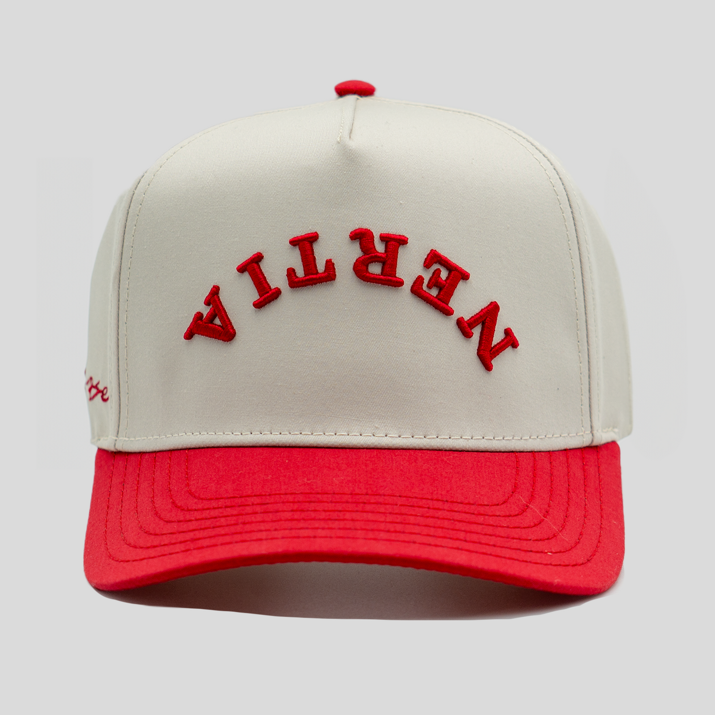 Beige and red cap with 'Nevian' branding on a light gray background