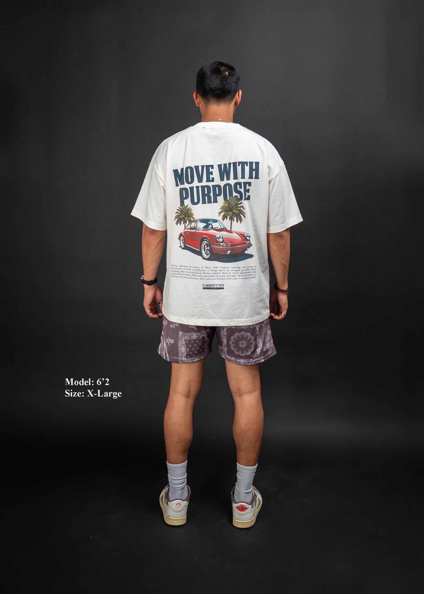 Person wearing a white t-shirt with 'Move with Purpose' text and graphic on the back, standing against a dark background.