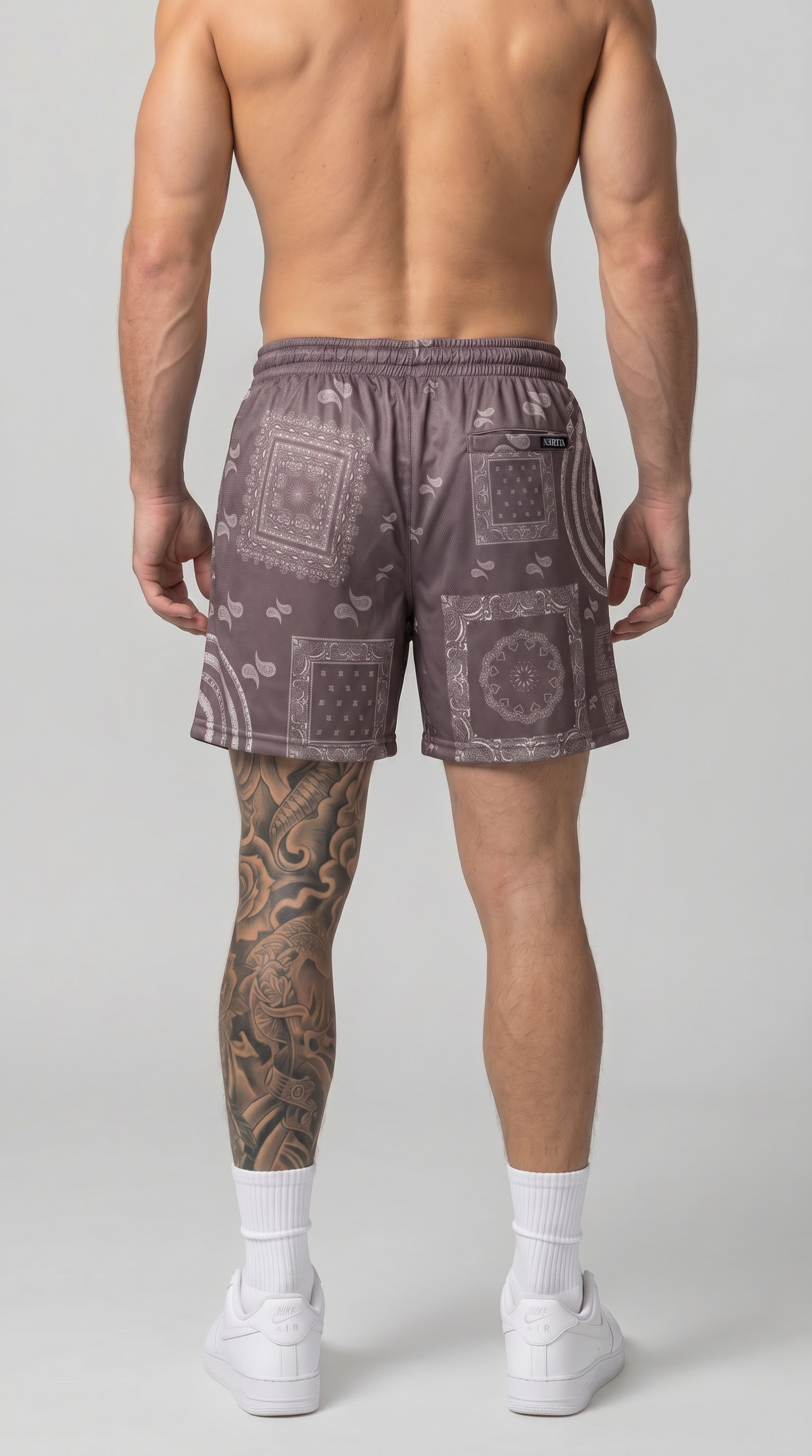 Man wearing patterned shorts on a plain background