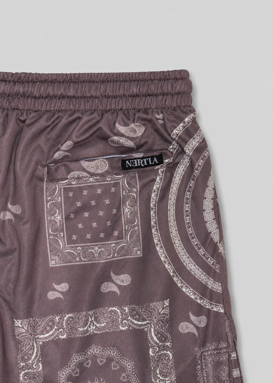 Brown shorts with bandana pattern and visible brand label on a light gray background