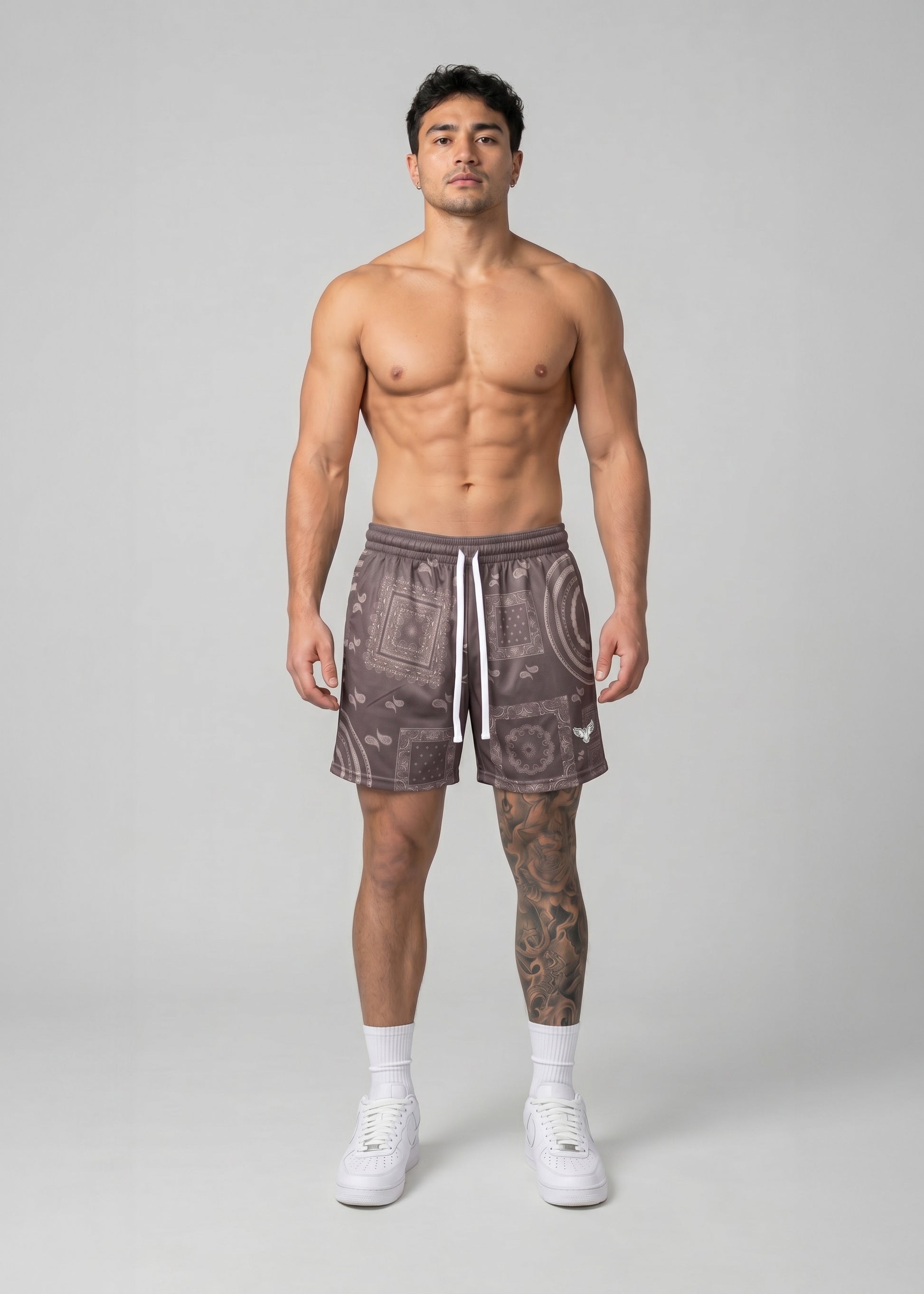 Man wearing patterned shorts on a plain background