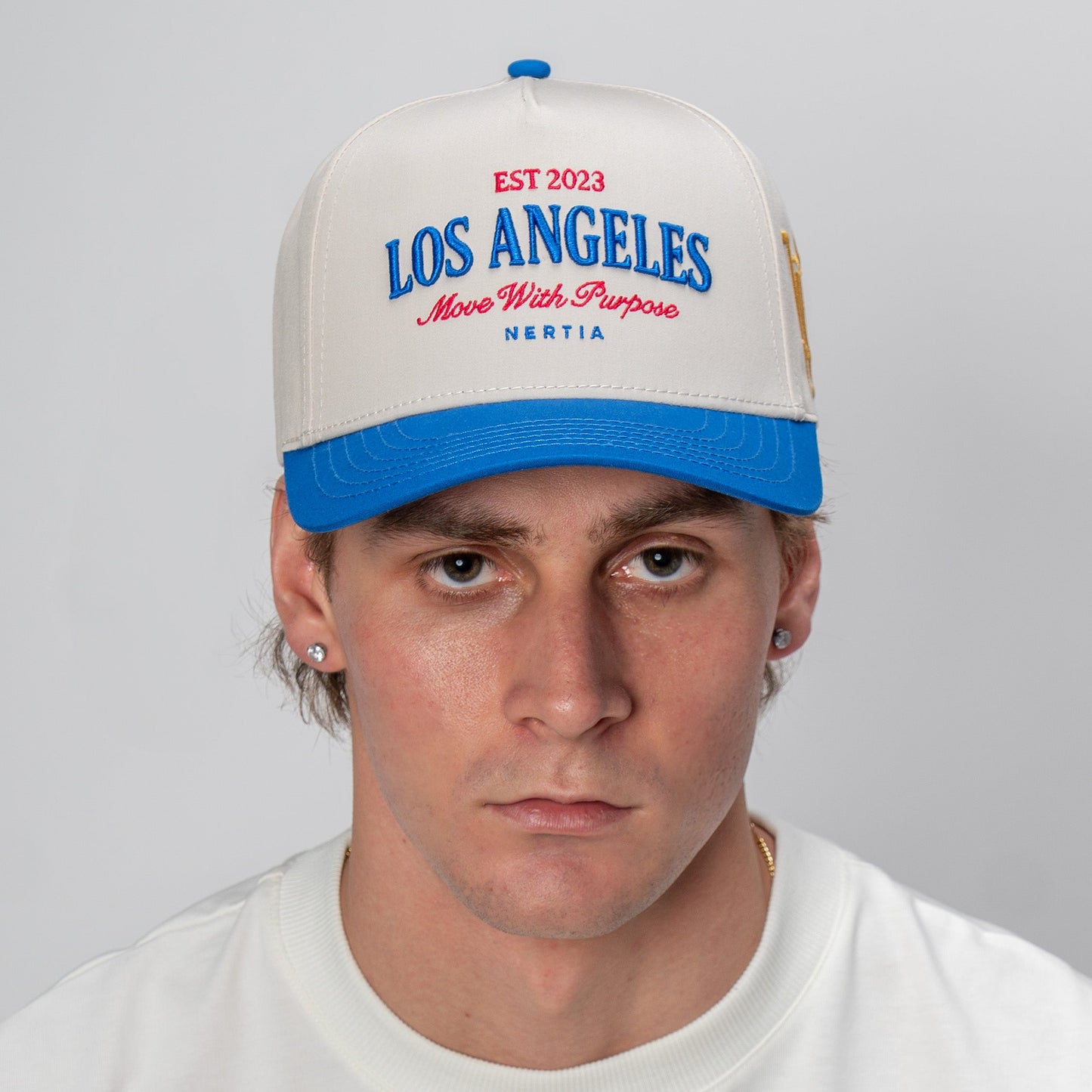 Person wearing a cap with 'Los Angeles' text on a plain background