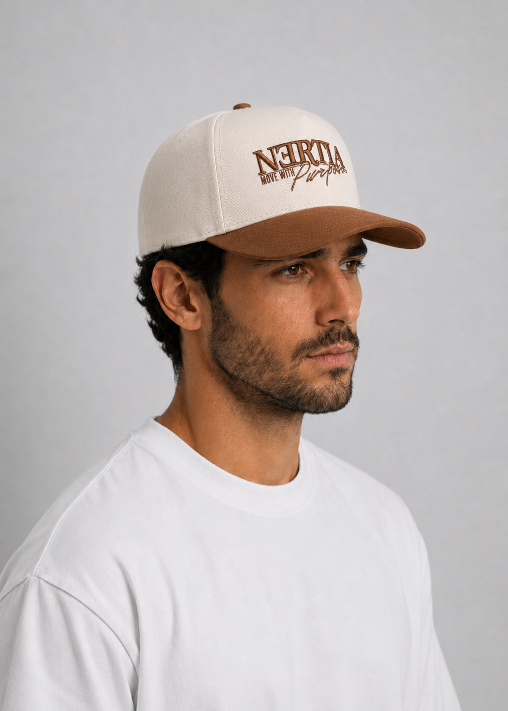 Man wearing a beige cap with text on a gray background
