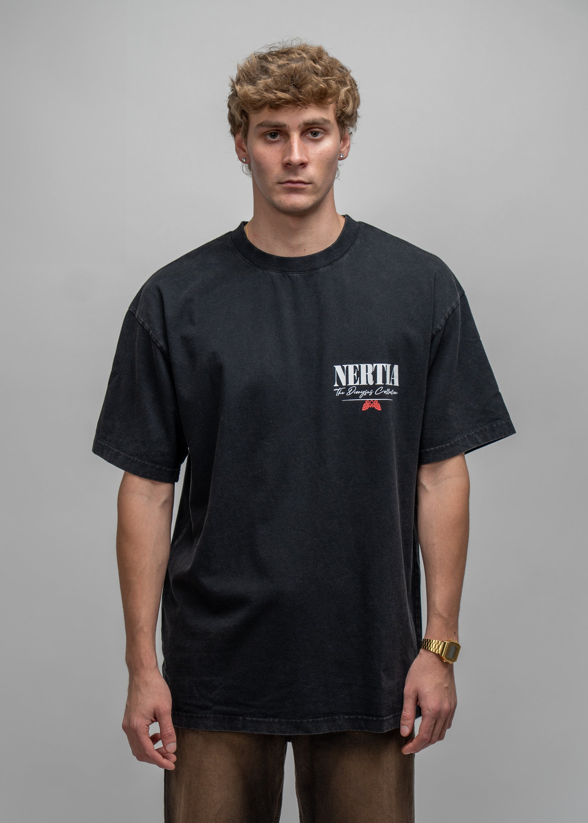 Man wearing a black t-shirt with a logo on a gray background