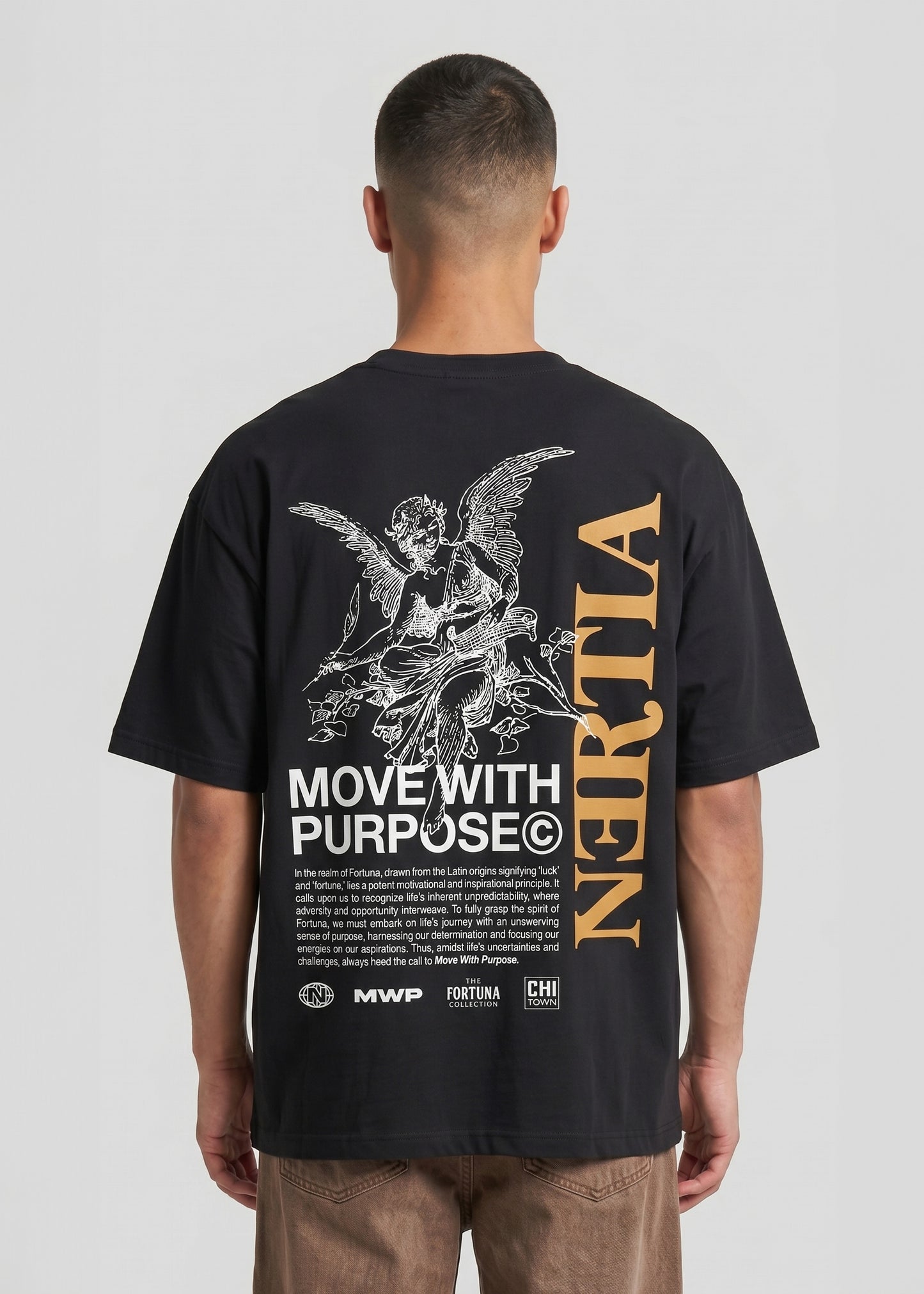 Person wearing a black t-shirt with text and graphics on the back, standing against a plain background