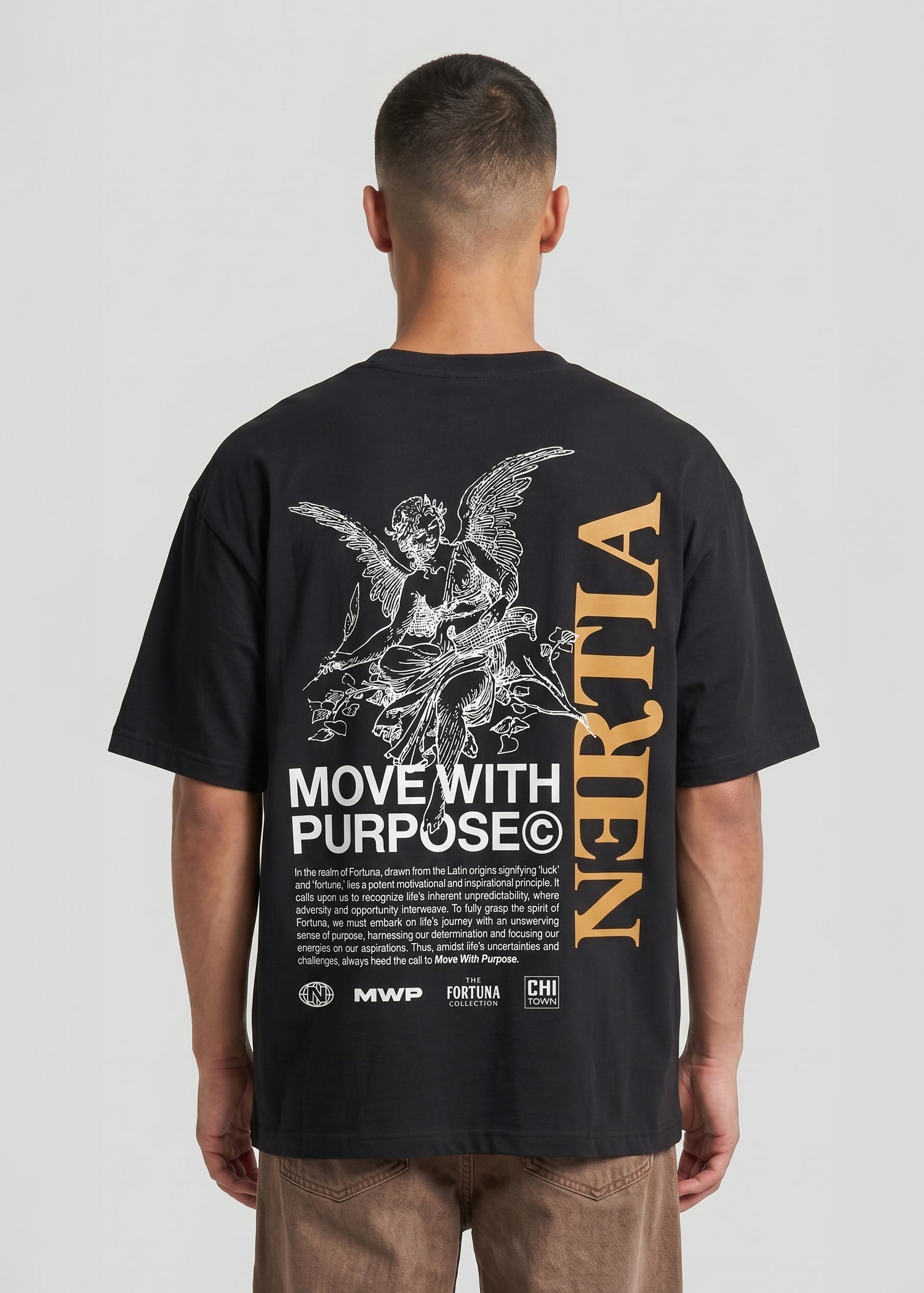 Person wearing a black t-shirt with text and graphics on the back, standing against a plain background