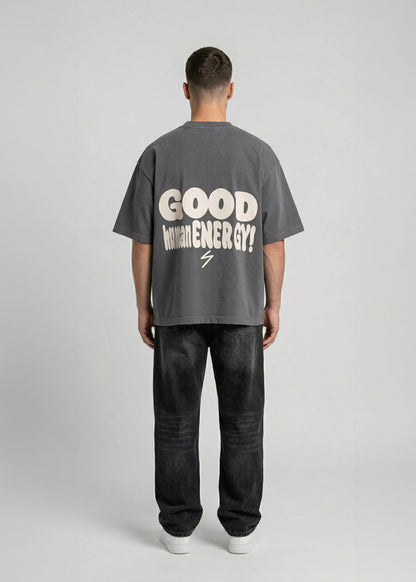 Person wearing a gray t-shirt with 'Good Vibes' text on the back, standing against a plain background