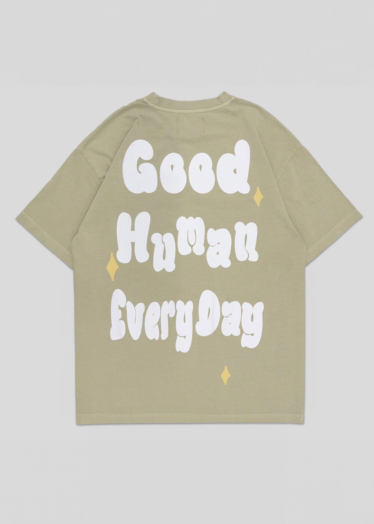 Beige t-shirt with 'Good Human Every Day' text on a light gray background