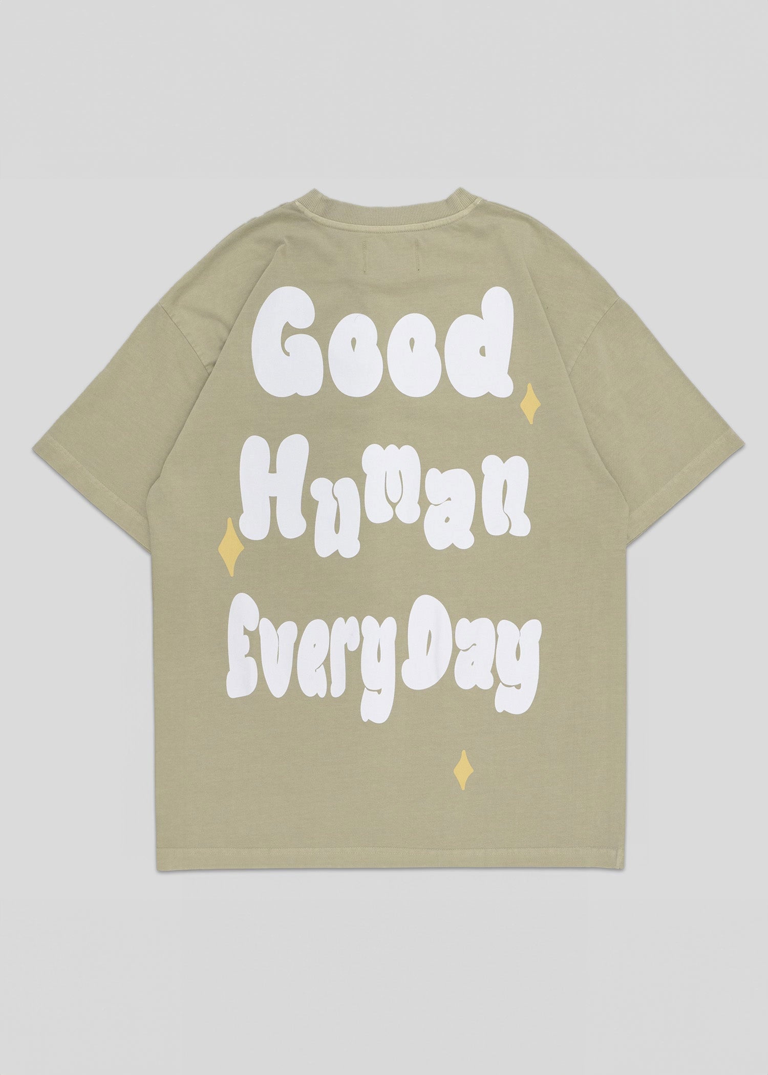 Beige t-shirt with 'Good Human Every Day' text on a light gray background