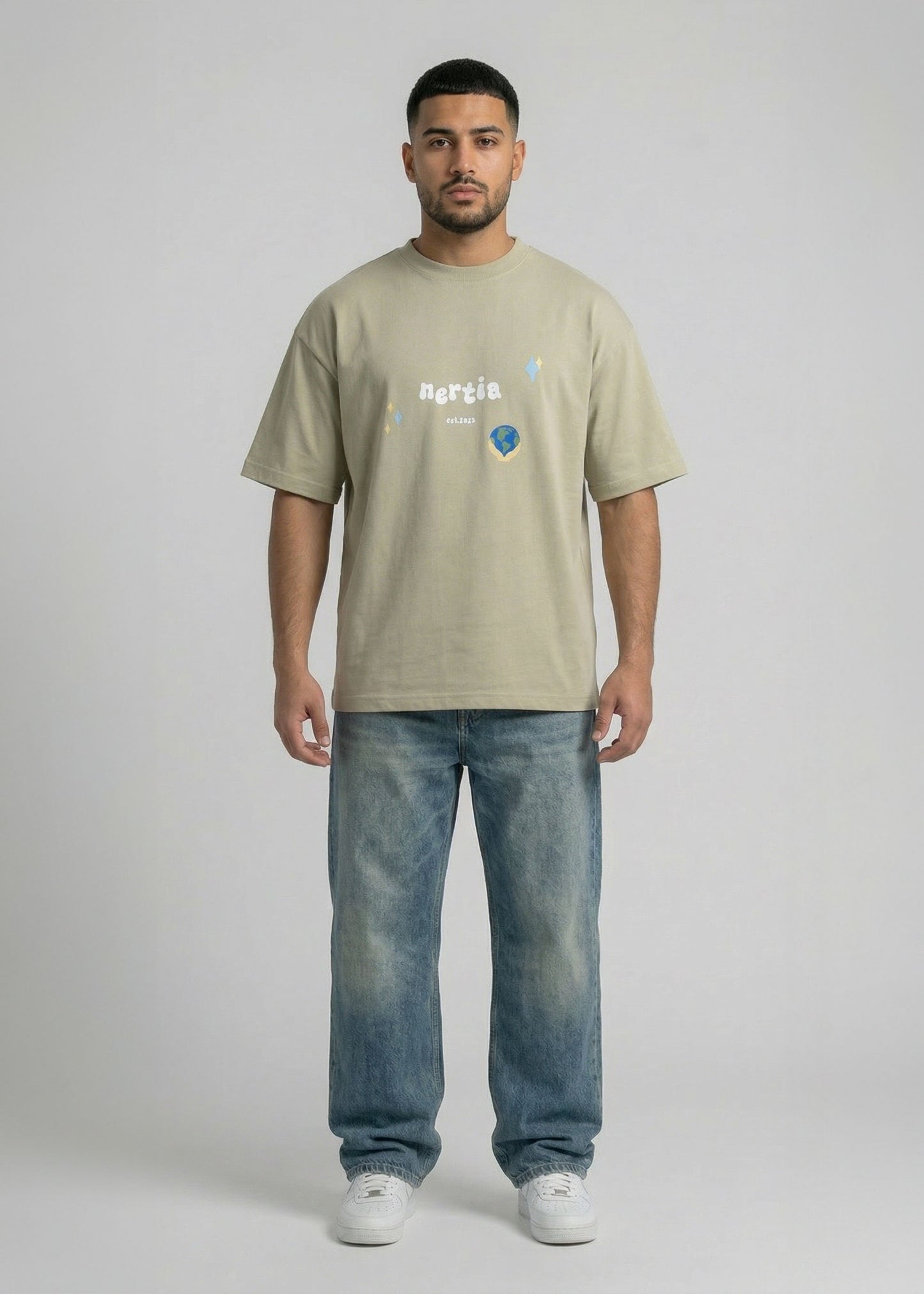 Man wearing a beige t-shirt with text and graphics, standing against a plain background