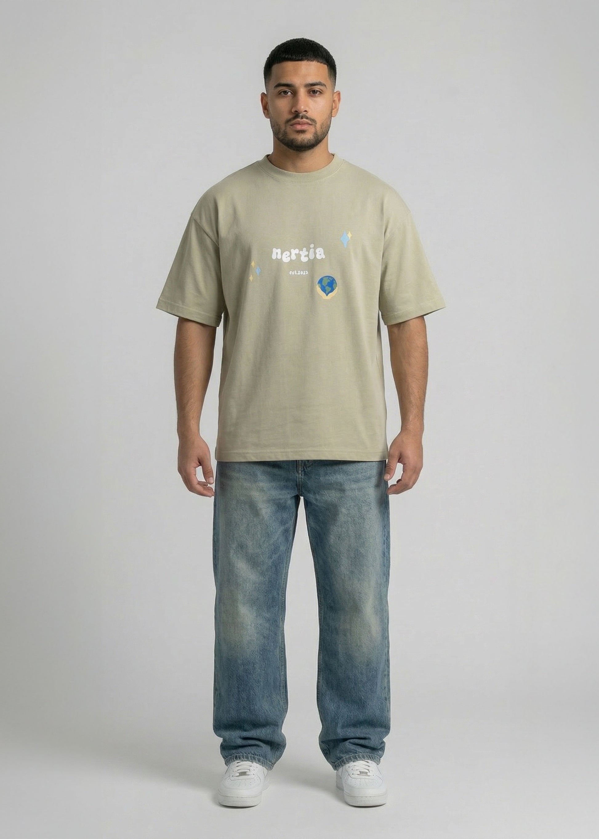 Man wearing a beige t-shirt with text and graphics, standing against a plain background