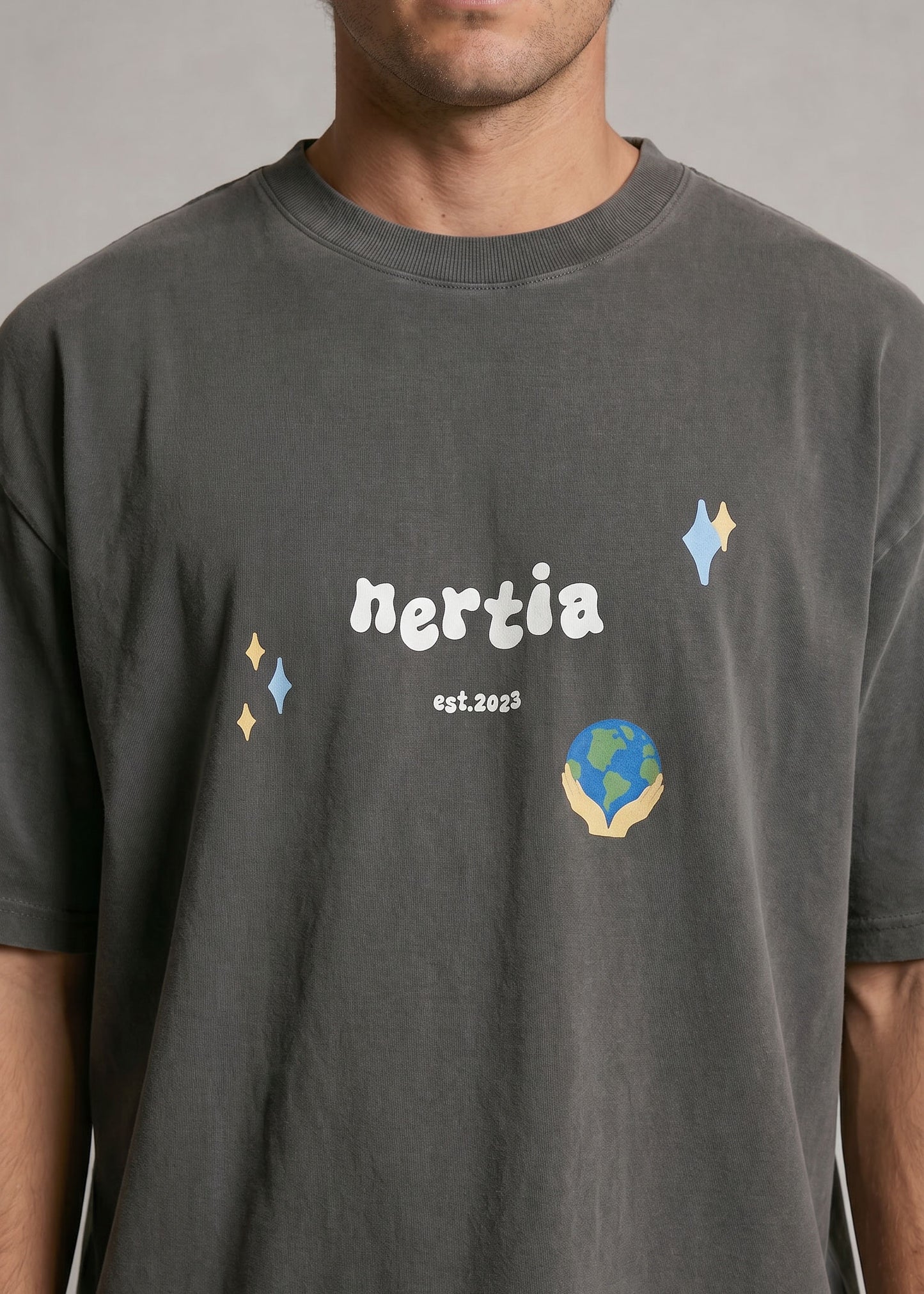 Person wearing a dark gray t-shirt with 'nertia' branding and graphics.