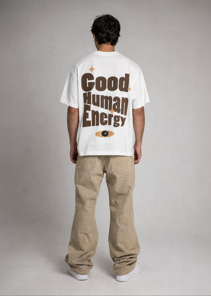 Person wearing a white t-shirt with 'Good Human Energy' text on the back, standing against a plain background.