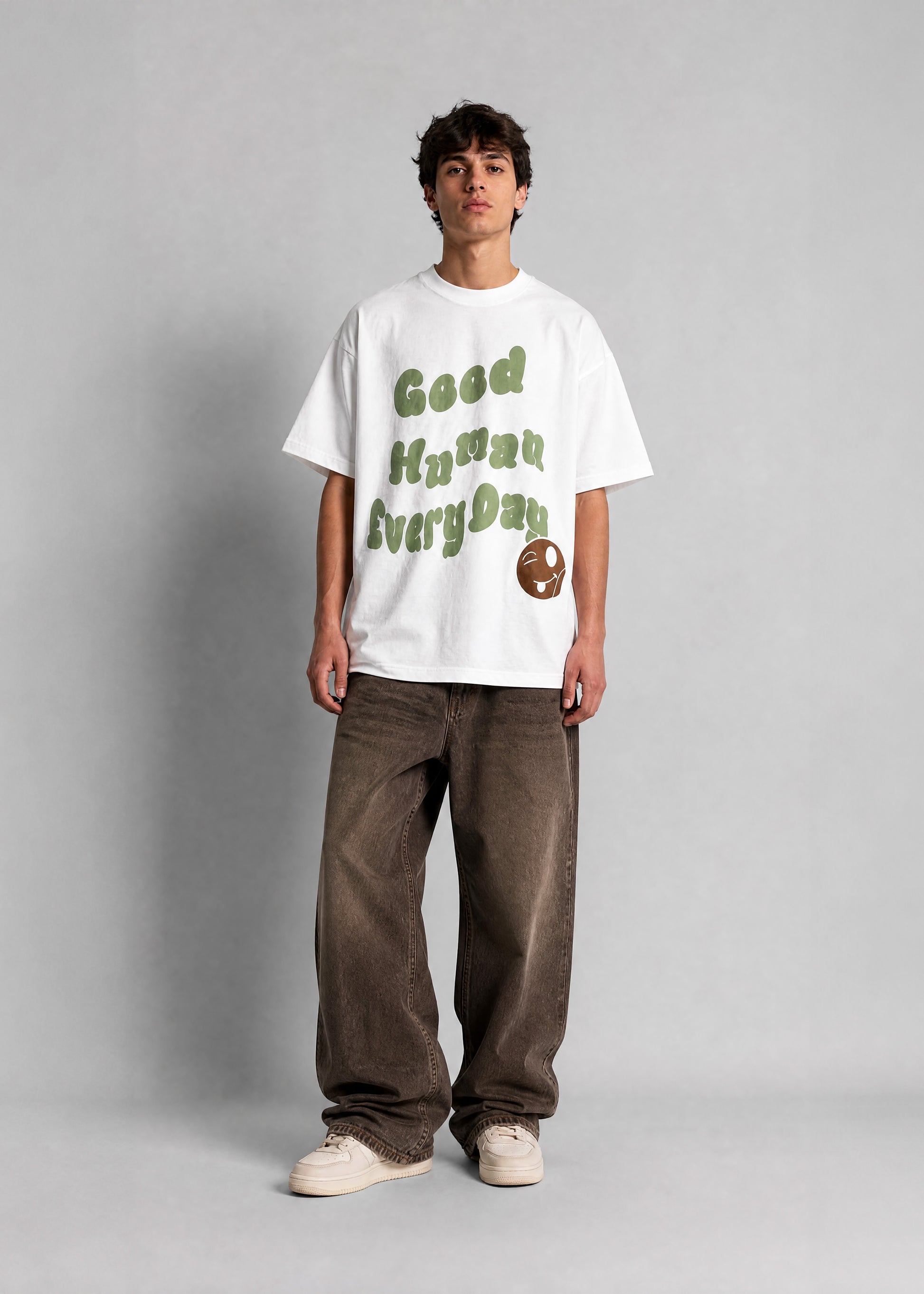 Person wearing a white t-shirt with text and graphics on a plain background