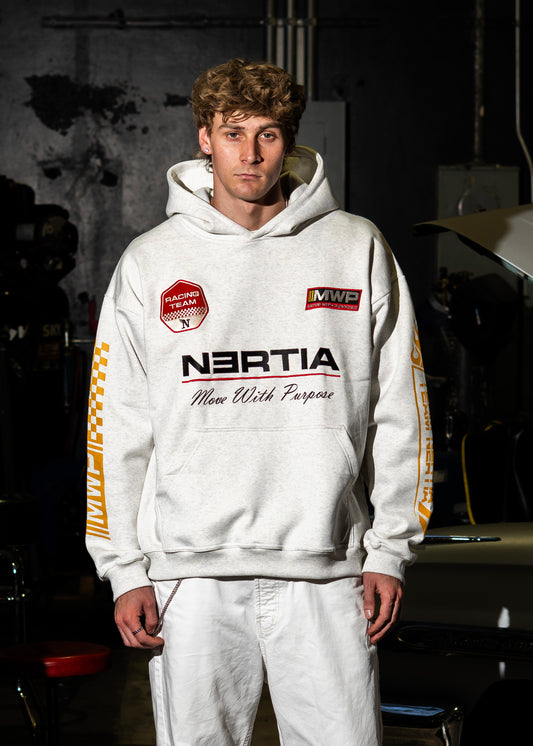 Person wearing a white hoodie with branding in a garage setting