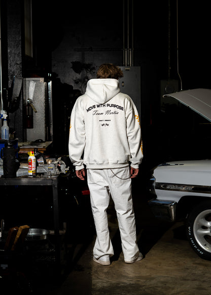 Person wearing a white hoodie and pants in a garage setting