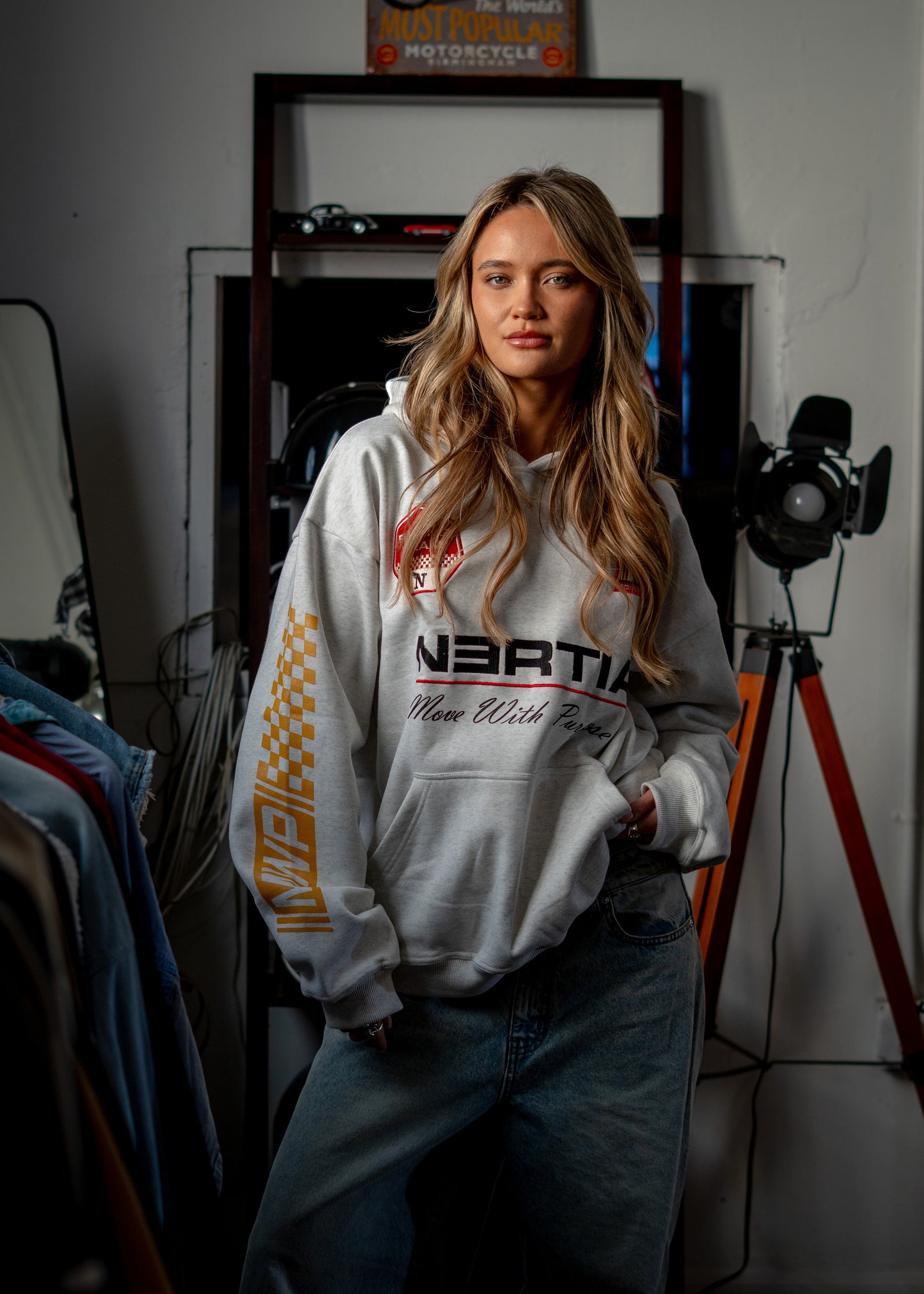 Person wearing a hoodie with branding in an indoor setting