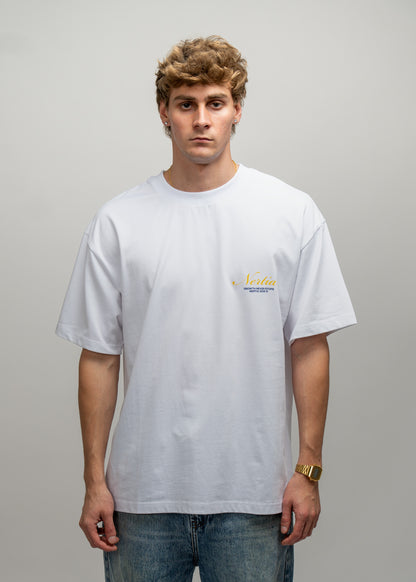 Man wearing a white t-shirt with a small logo on a gray background