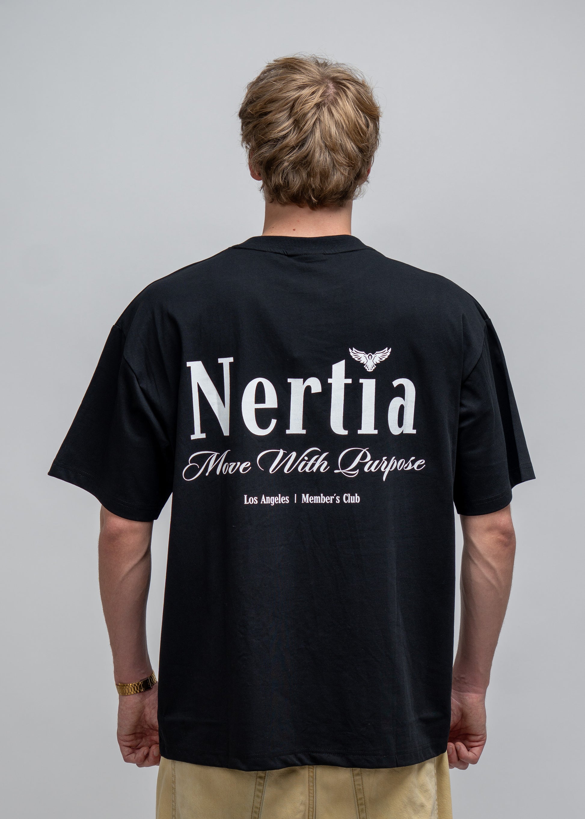 Person wearing a black t-shirt with 'Nertia' branding on the back against a gray background