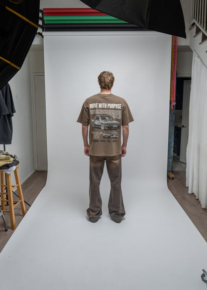 Person wearing a t-shirt with graphic design on a white backdrop in a studio setting