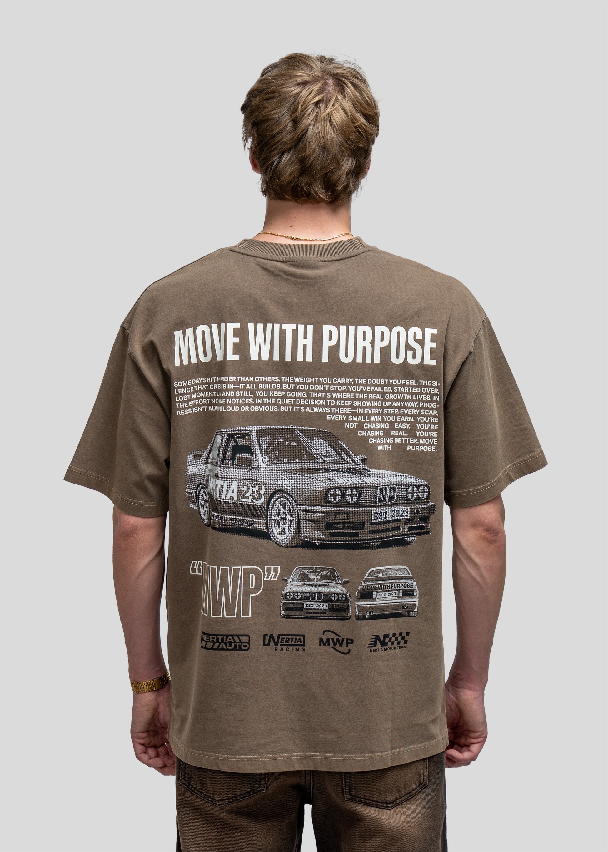 Person wearing a brown t-shirt with car graphics and text on the back