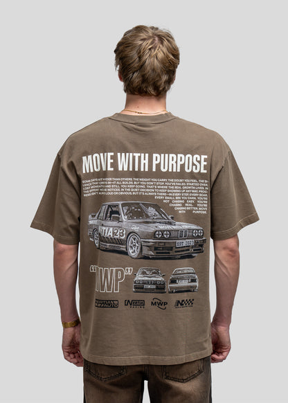 Person wearing a brown t-shirt with car graphics and text on the back