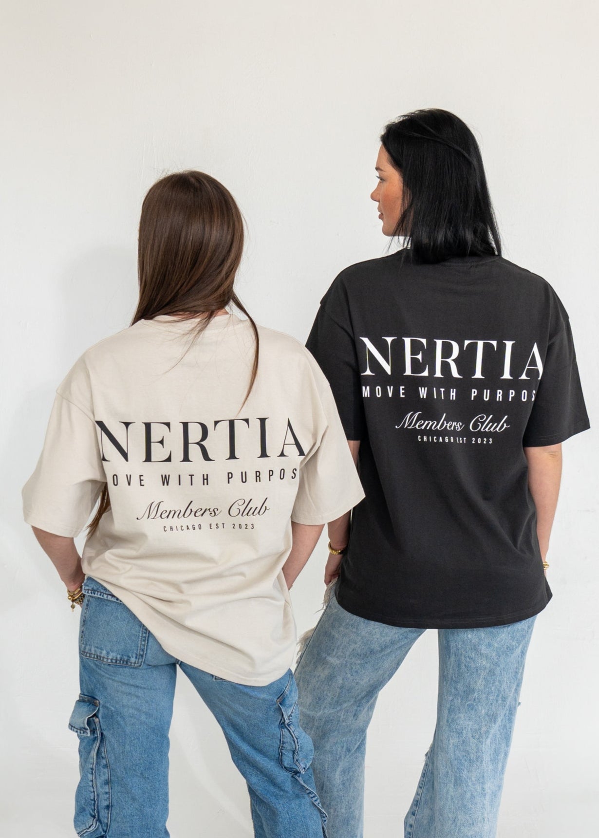 Two people wearing Nertia t-shirts with text on the back against a white background
