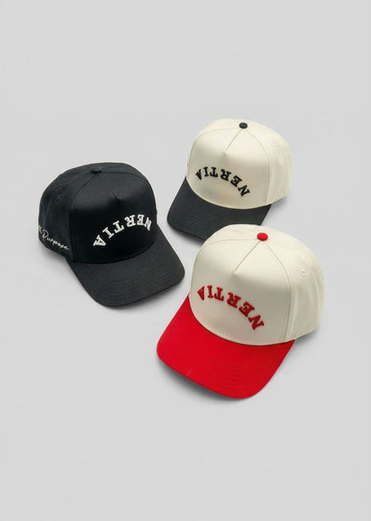 Three caps with 'Vlone' branding on a gray background
