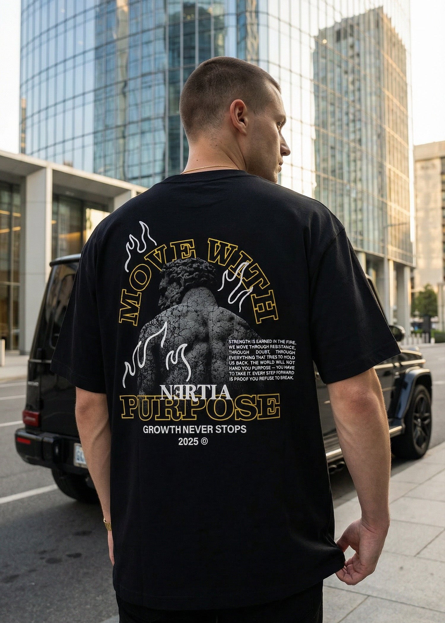 Man wearing a black t-shirt with a graphic design in an urban setting