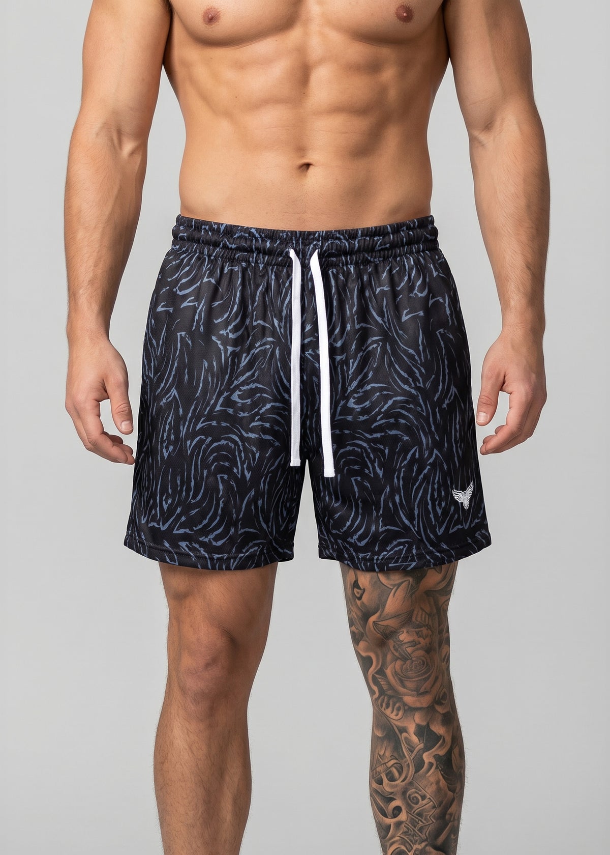 Man wearing navy patterned shorts on a gray background