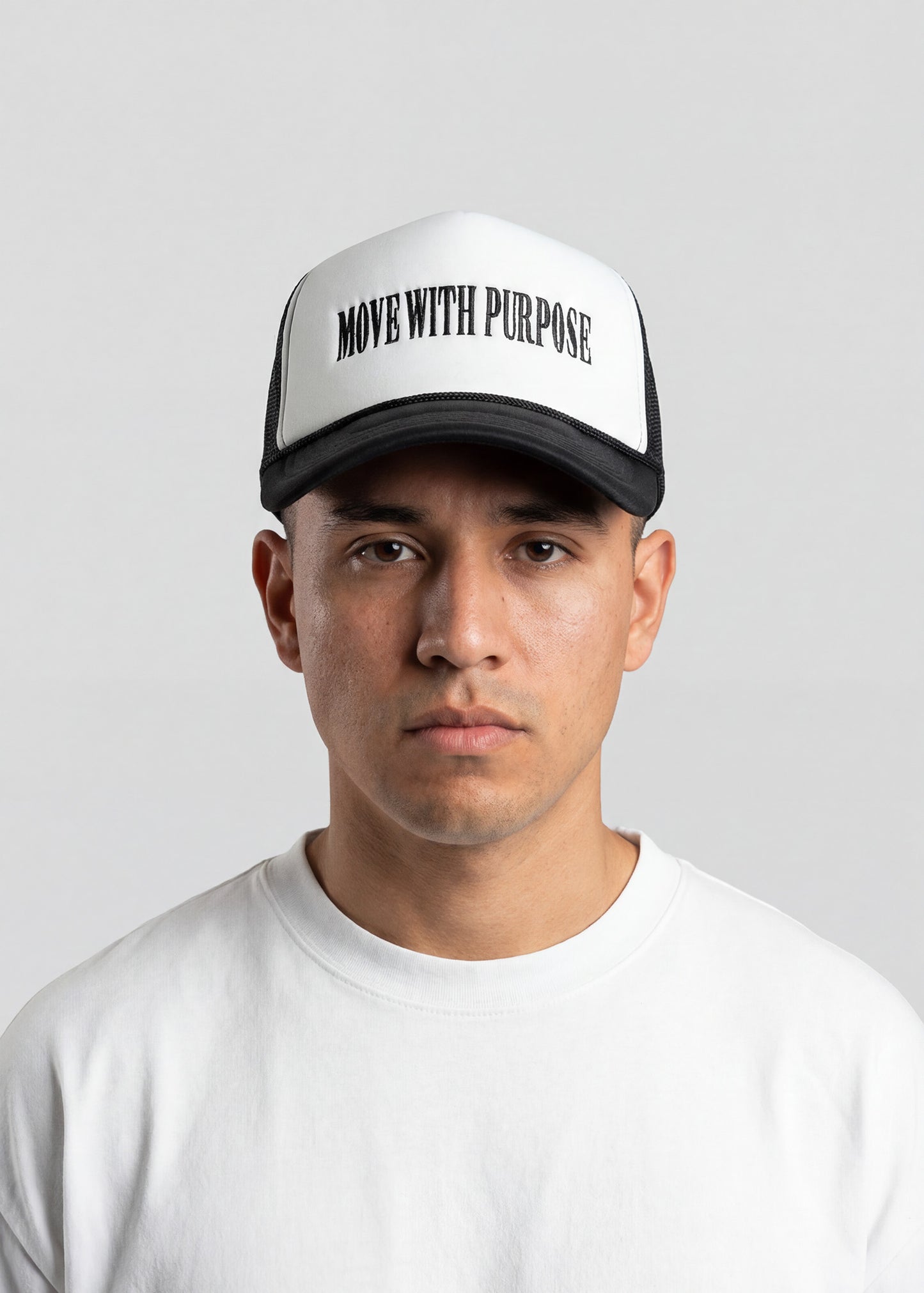 Person wearing a cap with 'Move with Purpose' text on a plain background
