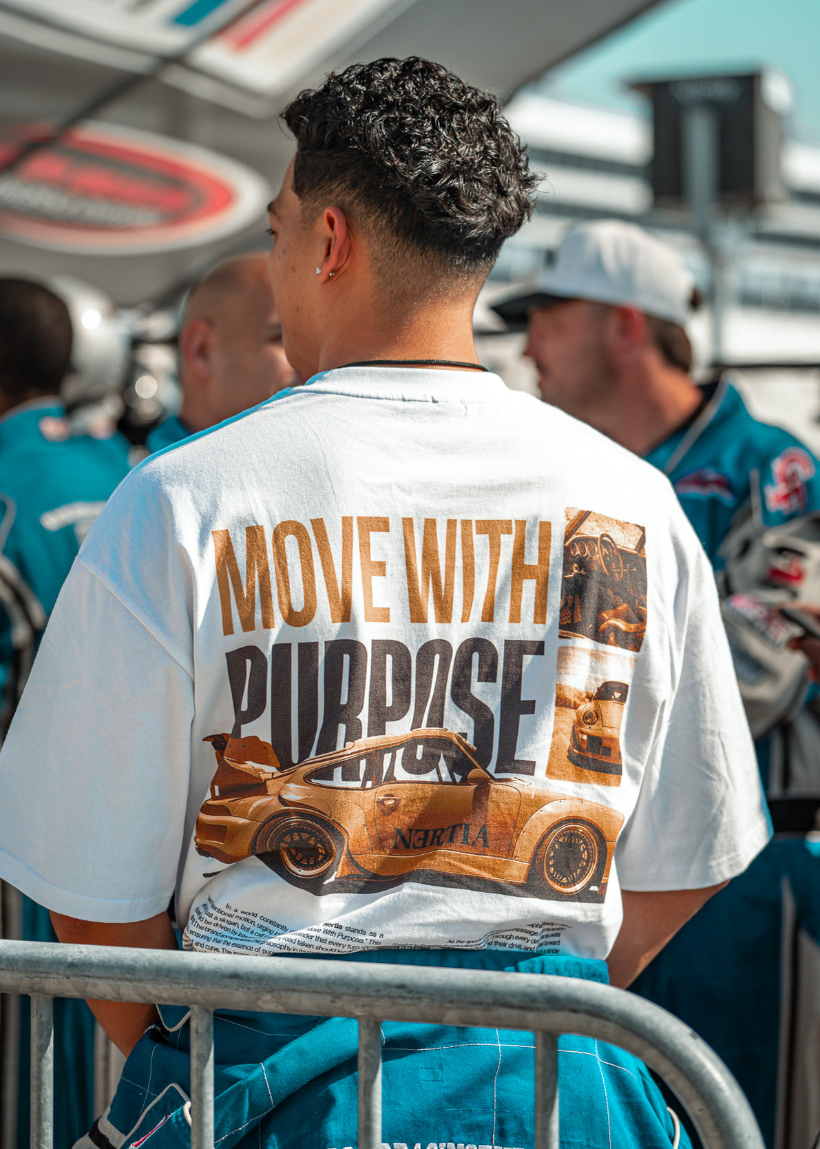 Guy wearing the V2 move with purpose shirt during the nascar driving