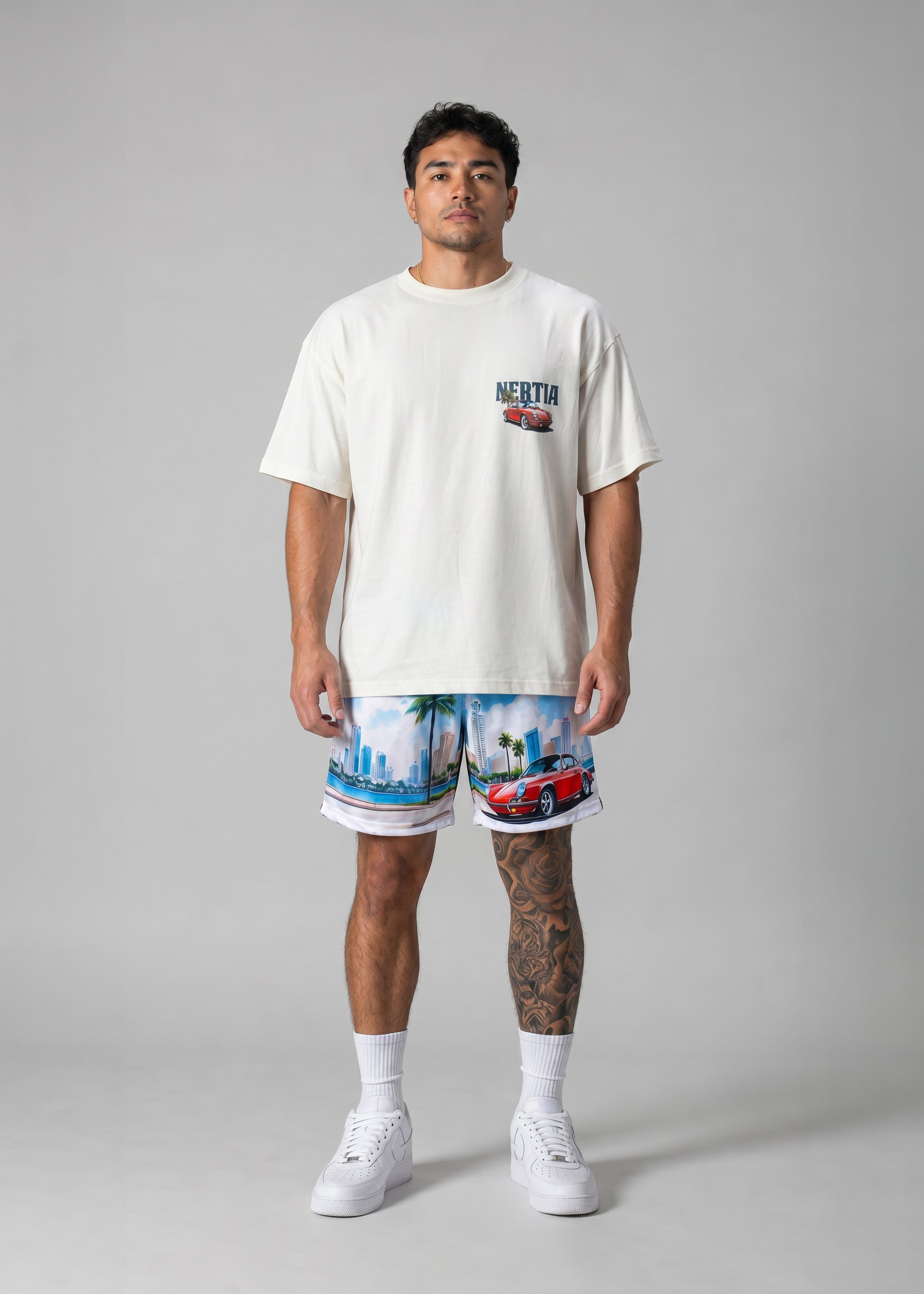 Man wearing a white t-shirt and colorful shorts on a gray background