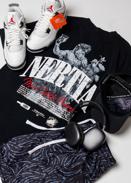 Black t-shirt with graphic design, white sneakers, and black headphones on a light gray background