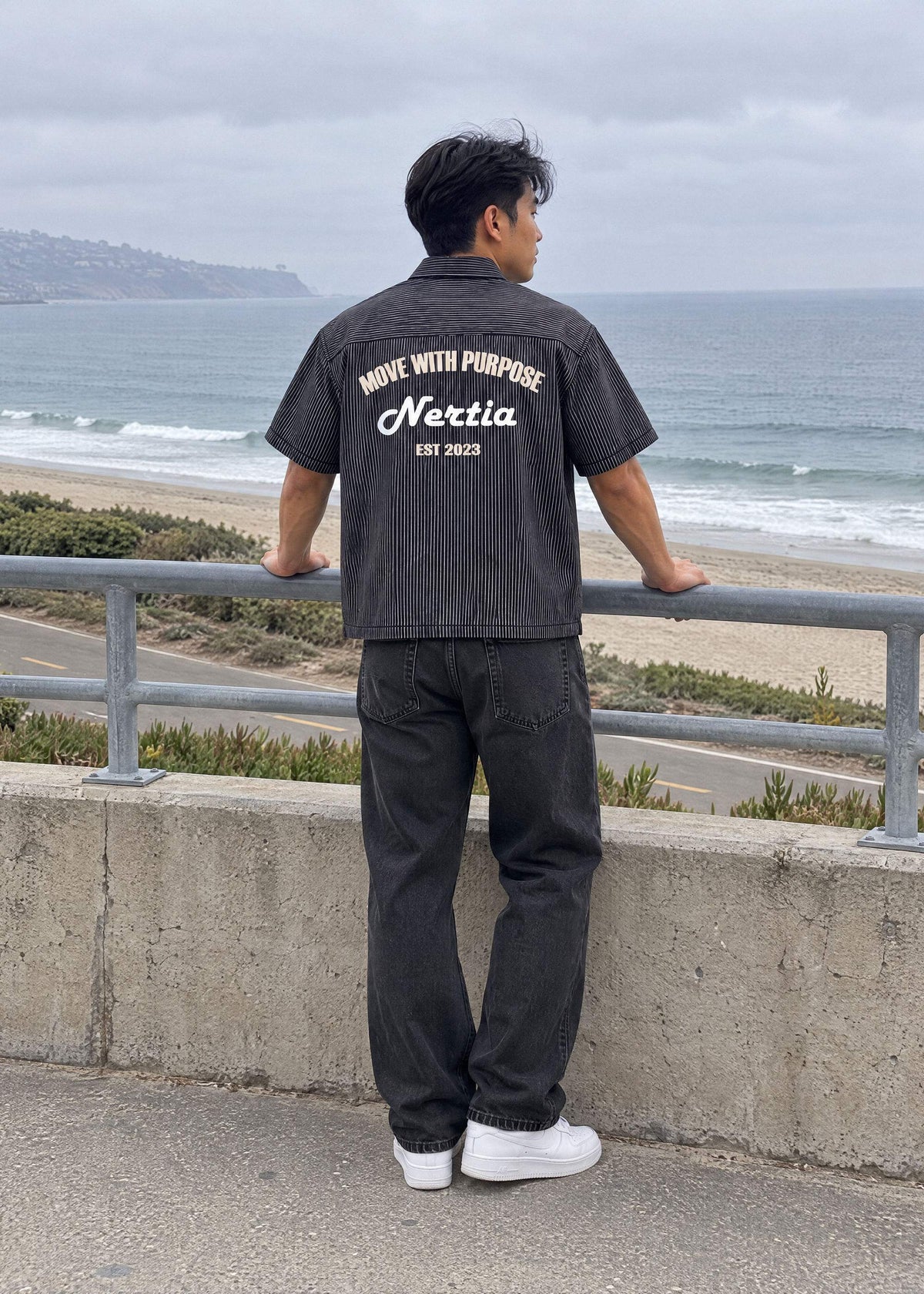 NERTIA Pit Crew Button-Down in black hickory stripe, Move With Purpose back print, worn at the Torrance Beach parking lot